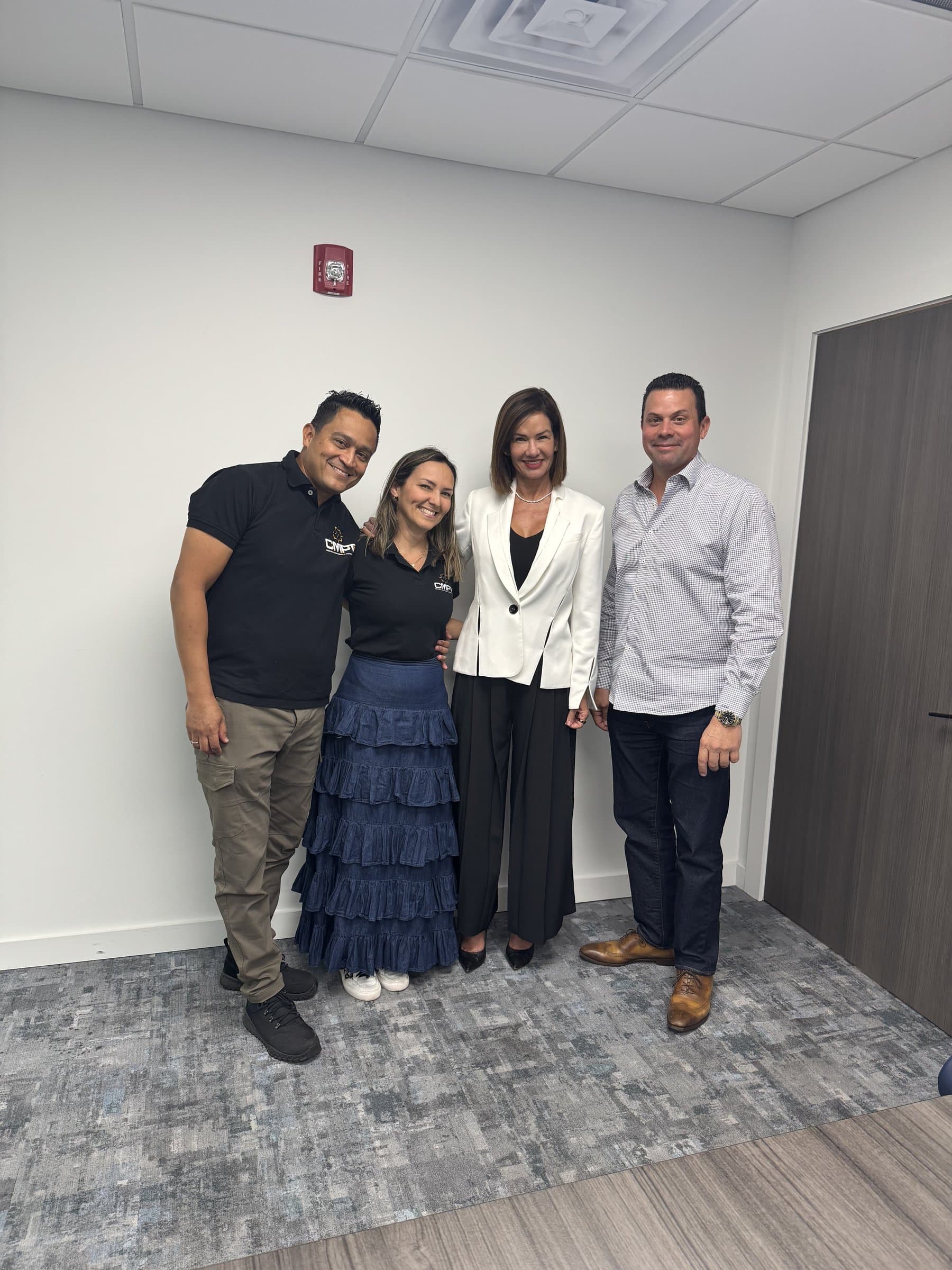 Dos clientes celebran la entrega de sus green cards con el equipo de GMC